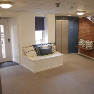 White entrance door with the lift to the right of it
