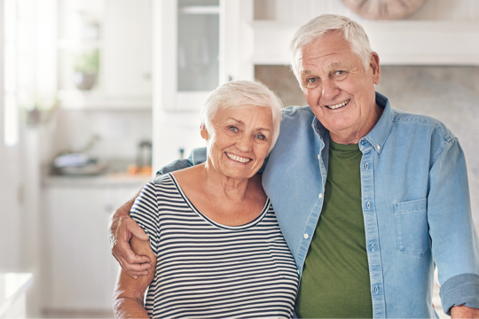 A couple holding each other by the kitchen counter 