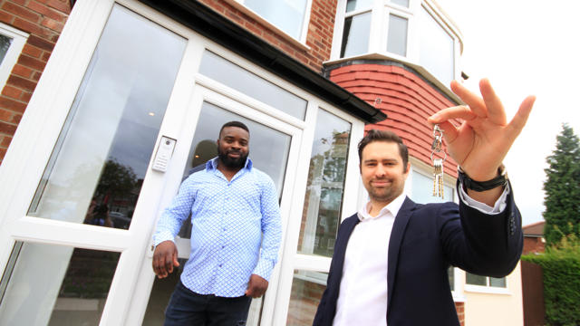 Two men showing their keys to their new property 