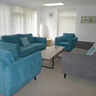Grey sofa and Blue chairs around a brown table
