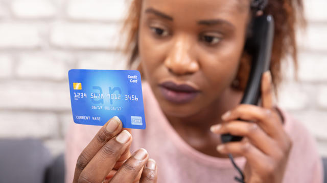 Woman on the phone looking at her credit card