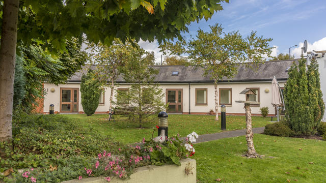 Flowery Garden and Blue Sky with the Shore Green building in the background