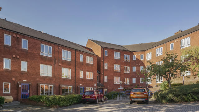 The front of Eastwood court building with cars parked outside the entrance
