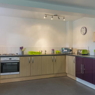 Busy Kitchen with both brown and purple coloured cupboards