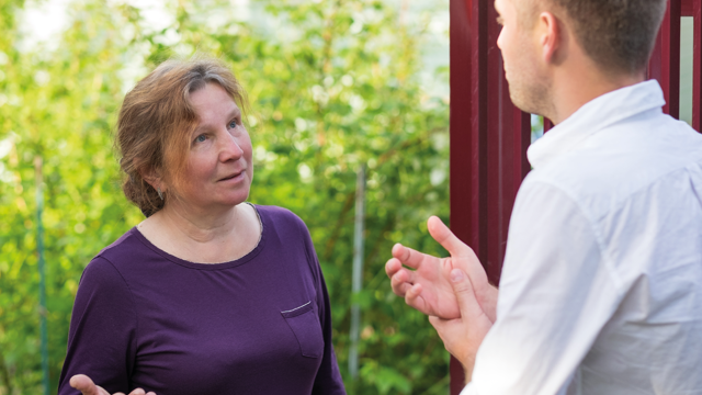 A man talking with a woman outside 