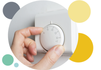 A persons hand adjusting the thermostat 