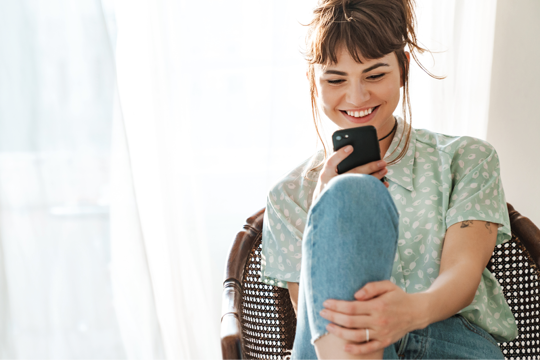 Woman staring at her phone with a smile