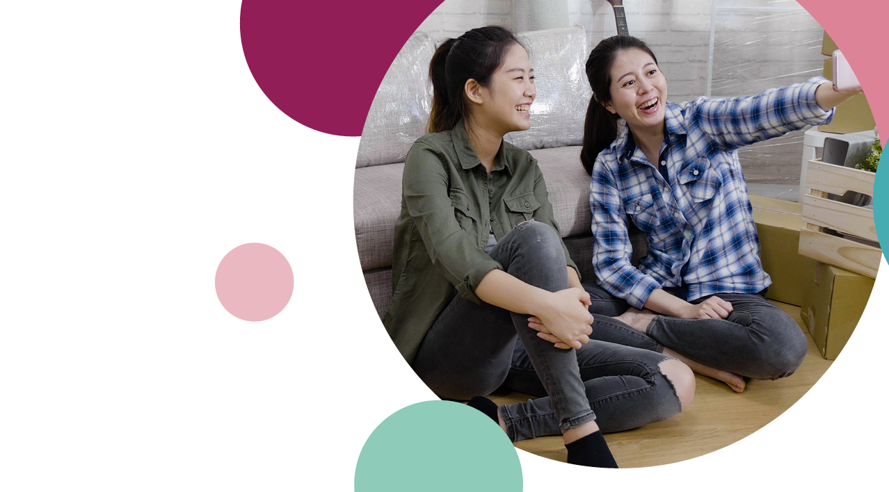 Two residents sitting on the floor laughing 