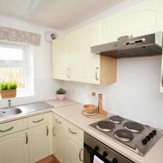 Cream coloured cupboards with an oven in the kitchen