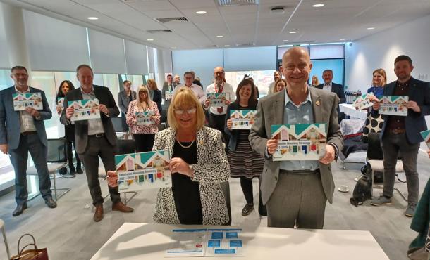 Irwell valley staff holding posters of Tameside houses proudly to celebrate the launch