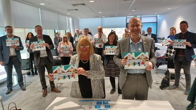 Irwell valley staff holding posters of Tameside houses proudly to celebrate the launch