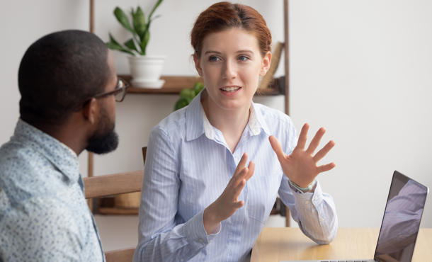 Woman explaining something on the computer to a man.