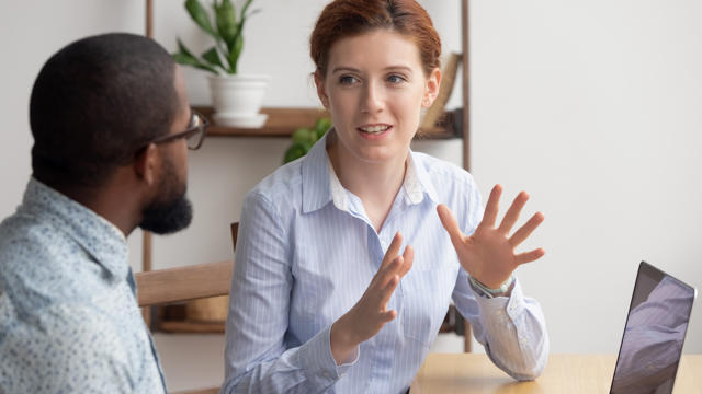 Woman explaining something on the computer to a man.