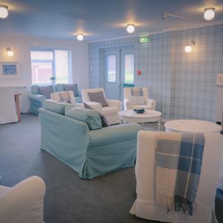 Blue and White chairs in a blue coloured communal room 