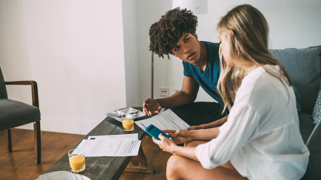 Couple using a calculator to analyse their financial status 