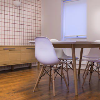 Checkered wallpaper with brown table and pink chairs