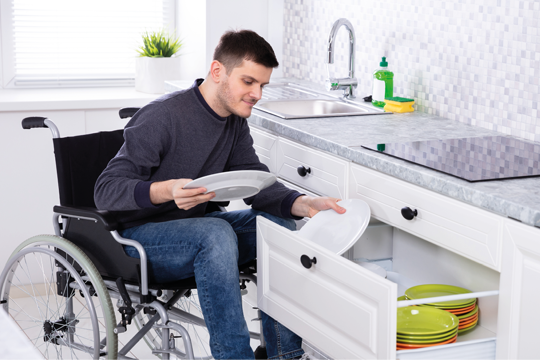 A man in a wheelchair filling his draw with his plates