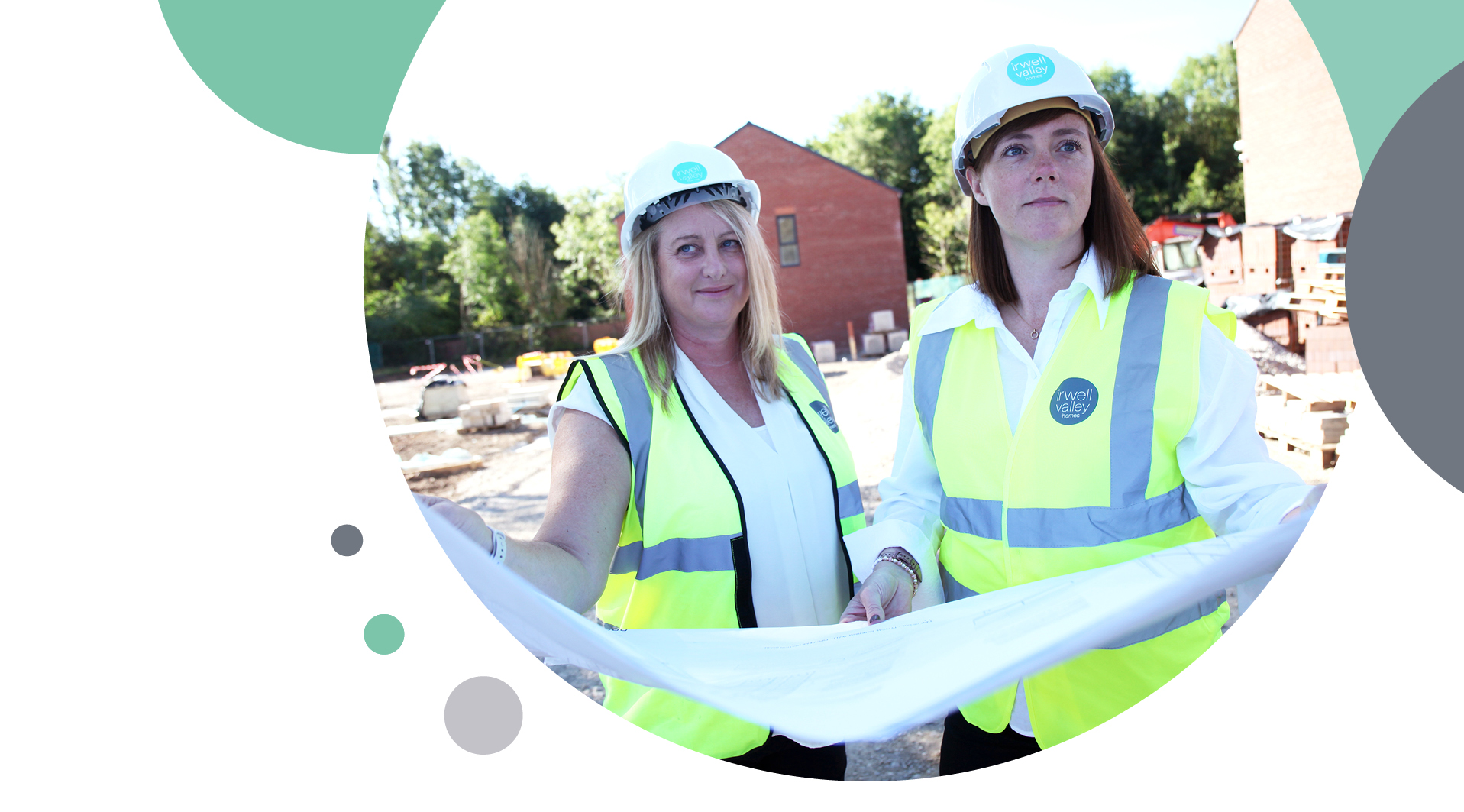 Two Irwell Valley staff in hi vis clothes reading the construction plans