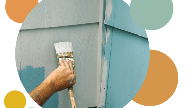 A man holding a paint brush painting the wall blue 