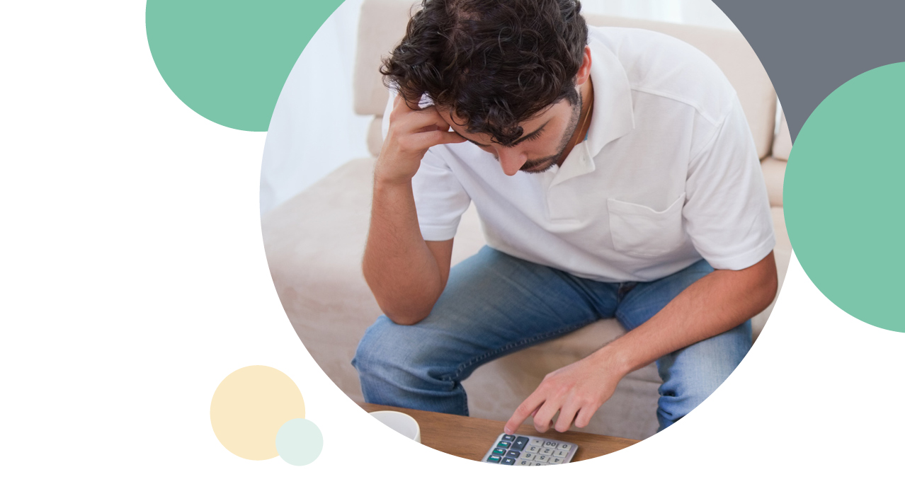 A man looking stressed whilst on the calculator