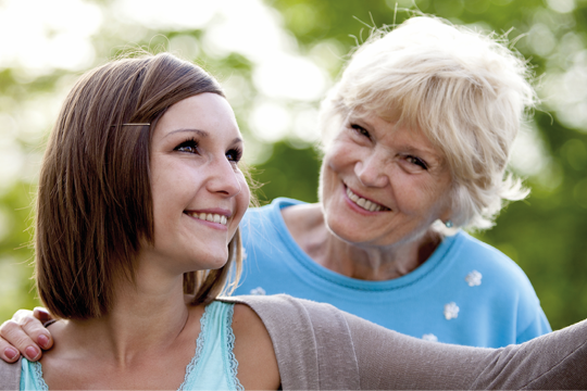 Two residents smiling and looking in the distance 