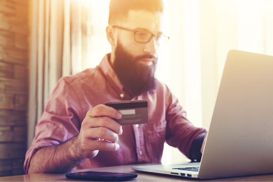 A man on his laptop analysing his credit card