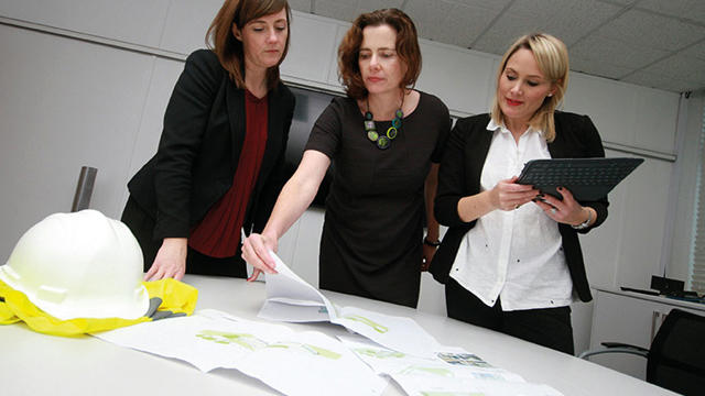 Three Irwell Valley employees examining a construction plan