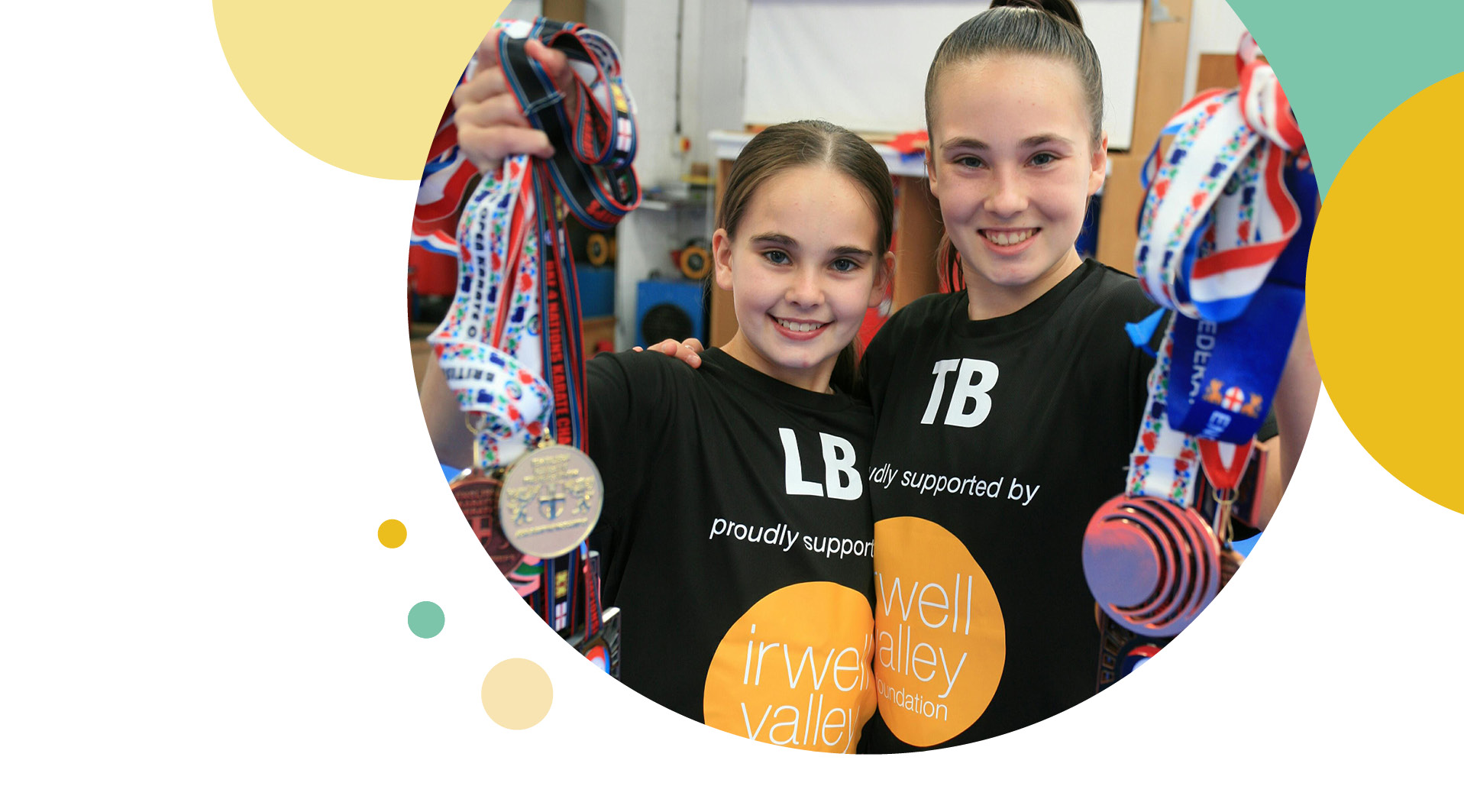 Two girls holding up their medals