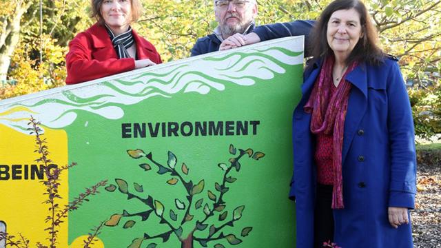 Claire Griffiths, Ralph Rudden and Sasha Deepwell standing by an environmental painting