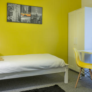 Room with yellow wallpaper and white furniture with laptop on the desk
