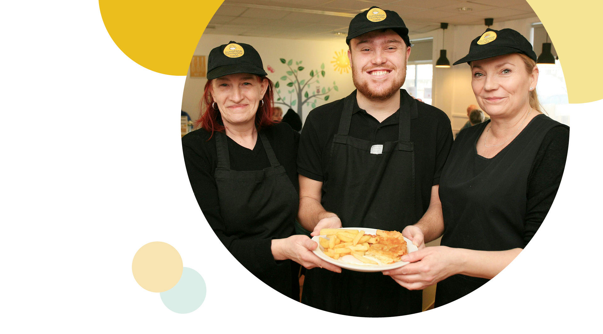 Three sunshine café employees holding a plate of food