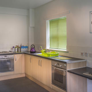 Busy Kitchen with brown cupboards and green blinds
