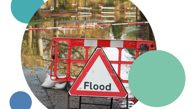 Flood warning sign and barrier in front of water