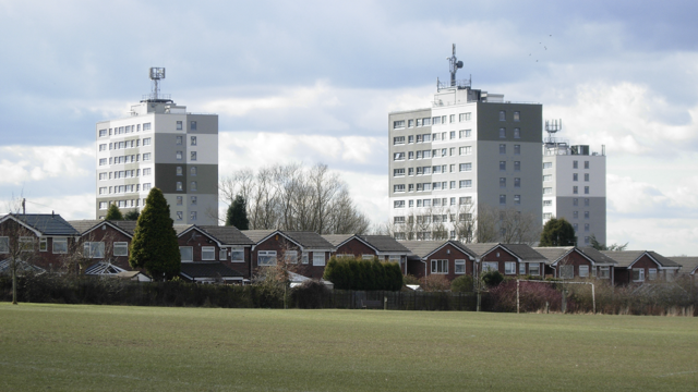 Three council flats in Manchester pictured above the houses and football pitch 
